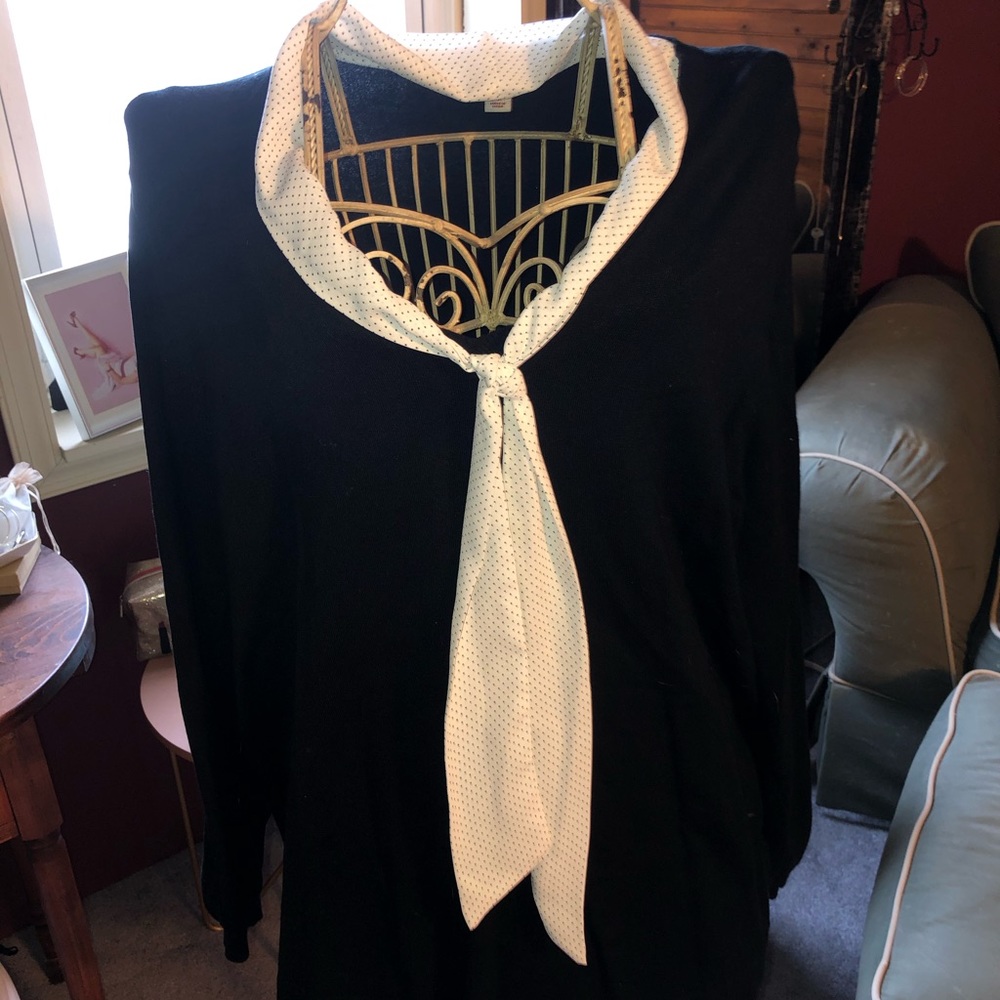 Black sweater with white polka dot tie.